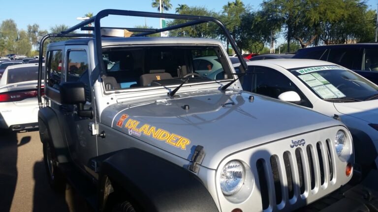 Technician lifting roll bar to access windshield during Jeep Wrangler windshield replacement in Mesa Arizona