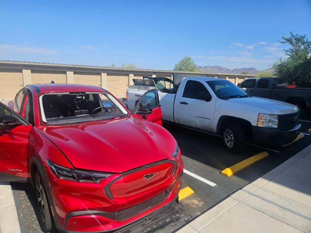 Technician replacing windshield on Ford Mustang Mach E in Apache Junction Arizona with ADAS calibration required through Allstate insurance.