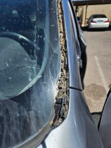 Excess glue from failed 2017 BMW X3 windshield replacement in Phoenix before proper repair by 1st Shot Auto Glass.