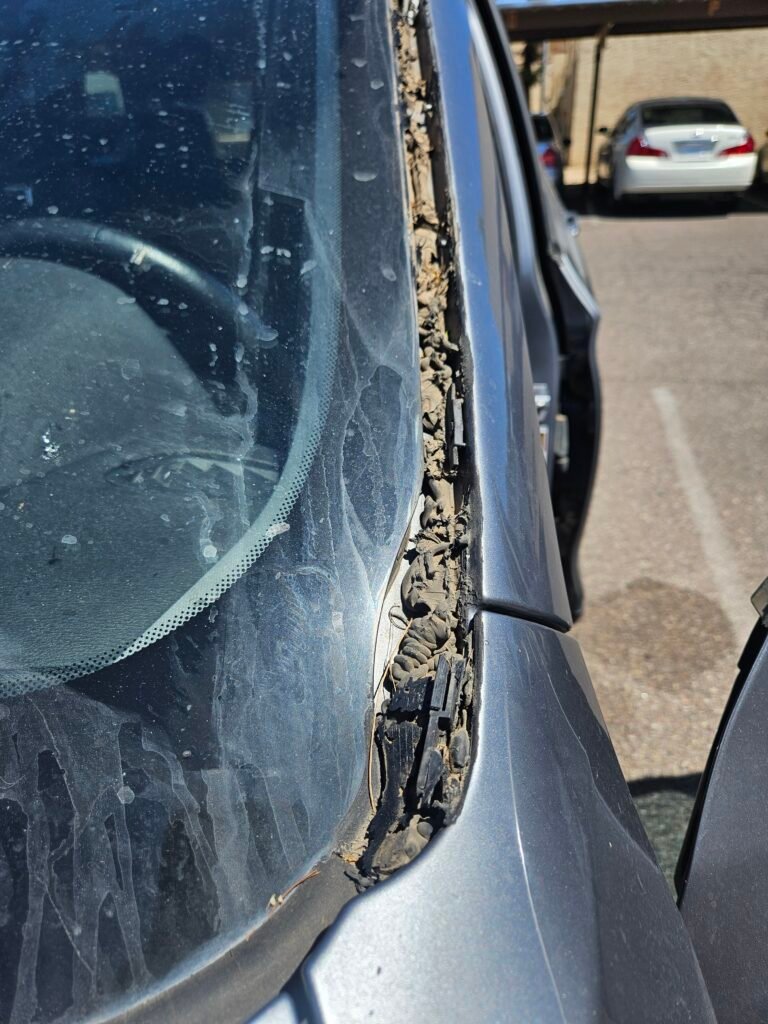 Excess glue from failed 2017 BMW X3 windshield replacement in Phoenix before proper repair by 1st Shot Auto Glass.