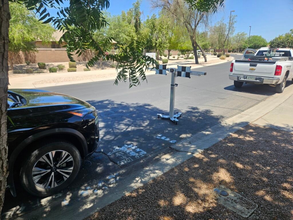 Static ADAS calibration setup for a Nissan Rogue after windshield replacement in Gilbert, Arizona using professional camera calibration equipment.