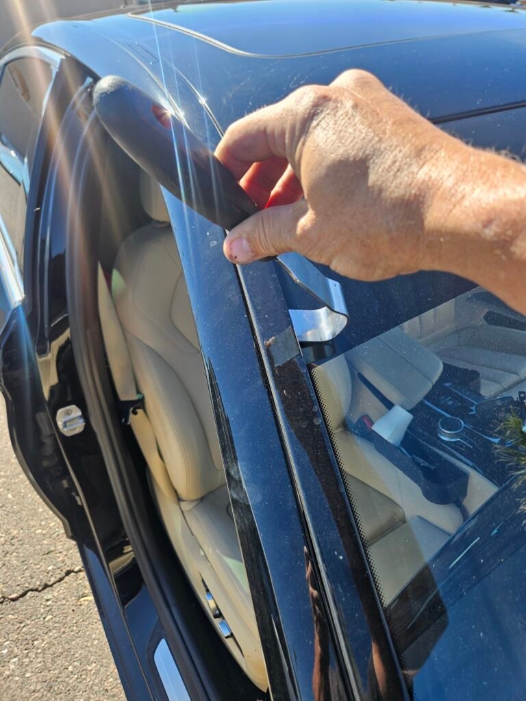 Removing the side windshield molding on a 2018 BMW 530i before windshield replacement in Mesa, AZ.