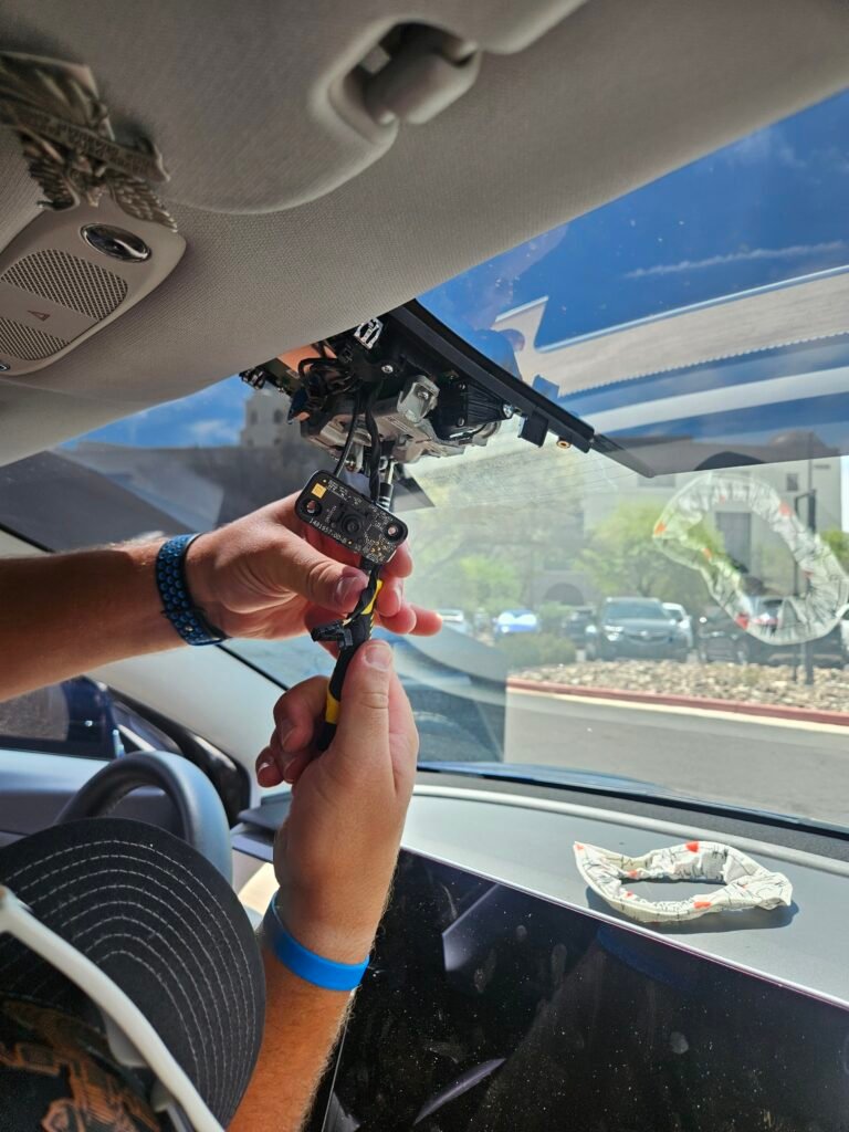 Technician replacing the rain and condensation sensor in a 2020 Tesla Model 3 in Gilbert, Arizona