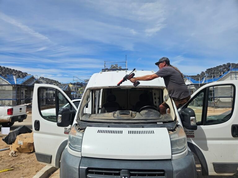 Patrick applying windshield adhesive to a 2018 Ram ProMaster in Queen Creek, Arizona
