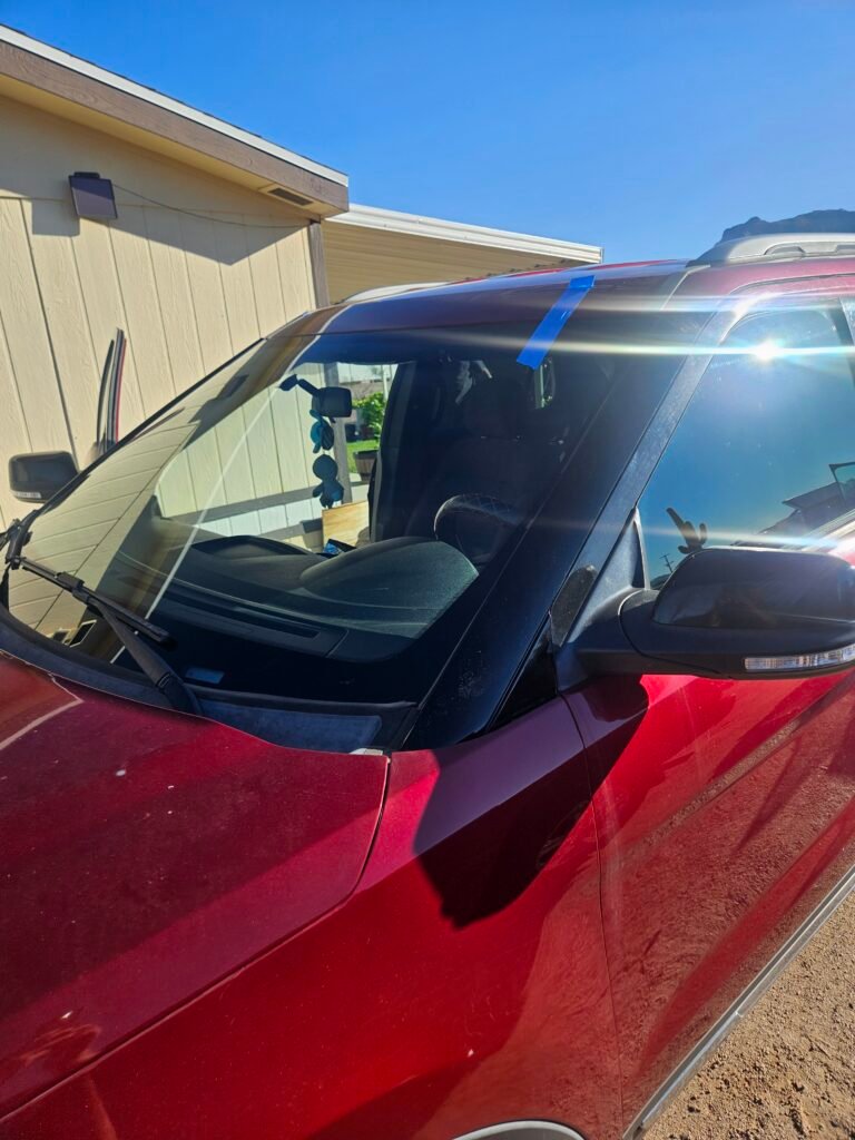 Red 2017 Ford Explorer with its replacement windshield and black side molding installed