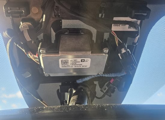 Mobile Windshield Replacement in Mesa, AZ & Greater Phoenix 3 Exposed forward-facing ADAS camera module and wiring in a 2026 Chevrolet Suburban Z71 during windshield replacement in Mesa AZ